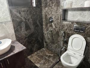 a bathroom with a shower and a toilet and a sink at Passaddhi Serviced Apartment F1 in Mysore +8 photos