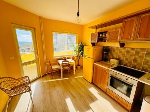 Sunrise Smart Home في مدينة فارنا: مطبخ بجدران صفراء وطاولة وكراسي