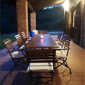 una mesa de madera y sillas en un patio por la noche en casa marconi, en Vetriano