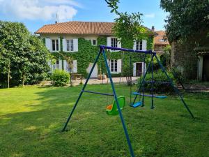 a swing set in a yard in front of a house at Fleur de Lys in Ansac-sur-Vienne