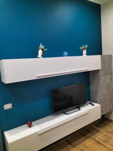 un soggiorno con TV e parete blu di San Sebastiano a Barletta