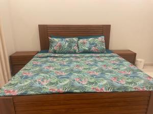 a bed with a colorful comforter and two pillows at Cozy Corner Homestay in Lahore