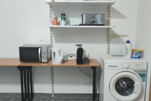 een keuken met een tafel, een magnetron en een wasmachine bij Ferienwohnung mit Garten in Wenen