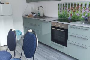 a kitchen with a sink and a stove and two chairs at Ferienwohnung mit Garten in Vienna
