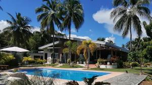 a house with a swimming pool and palm trees at Seaview Residence Garden Room1 in Binlod