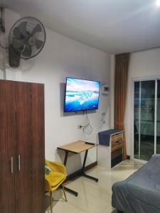 a living room with a flat screen tv on the wall at AA Apartment in Koh Samui 