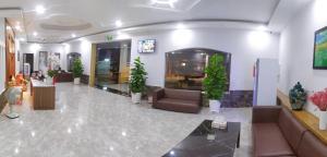a lobby with couches and plants in a building at Khách sạn Khang Điền 2 in Xóm Phước Mỹ