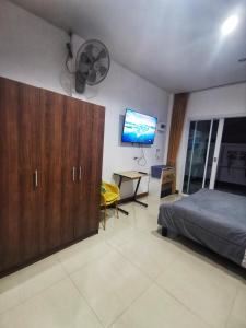 a bedroom with a bed and a desk and a flat screen tv at AA Apartment in Koh Samui 