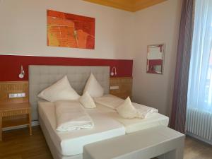 - une chambre avec un lit et des oreillers blancs dans l'établissement Villa Thea Hotel am Rosengarten, à Bad Kissingen