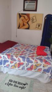 a bed with a quilt on it in a bedroom at Pousada do Sol in Rio de Janeiro