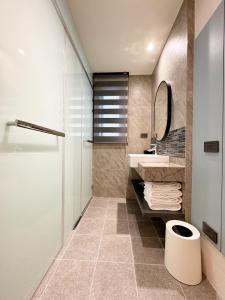 W łazience znajduje się umywalka i lustro. w obiekcie 逢甲享沃行旅 Joie de Inn w mieście Taizhong