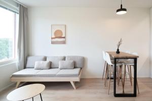 een woonkamer met een bank en een tafel bij Norden Homes Turku Nordic Apartment with Free Parking in Turku