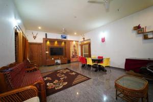 a living room with a couch and a table at Sugarcane Homestay in Attigundi