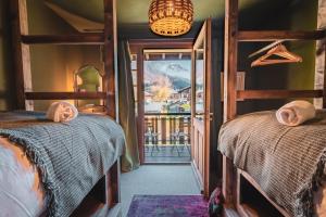 a bedroom with two bunk beds and a balcony at The Fat Fox Lodge, Morzine in Montriond