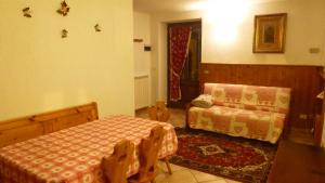 een slaapkamer met een bed, een bank en een tafel bij Bilocale Entrèves CIR 116 in Courmayeur