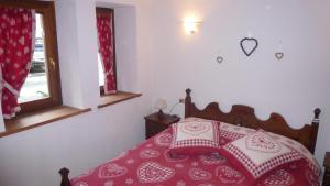 een slaapkamer met een bed met een rode en witte sprei bij Bilocale Entrèves CIR 116 in Courmayeur