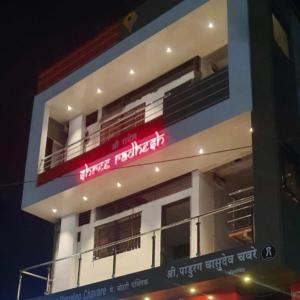 Shree Radhesh Bhakt Niwas في باندهاربور: مبنى أبيض عليه علامة حمراء