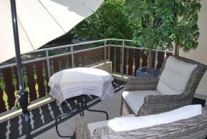 eine Terrasse mit 2 Stühlen und einem Sonnenschirm auf dem Balkon in der Unterkunft Ferienwohnung AltesSalzwerk in Bad Harzburg