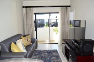 ein Wohnzimmer mit einem Sofa und einem TV in der Unterkunft Soldout Camp 1 in Johannesburg