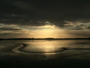 un tramonto su una spiaggia con l'oceano di Aussergewöhnliches Haus mit Sauna, Kamin und Garten a Wilhelmshaven