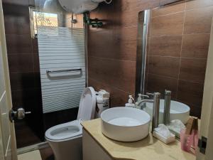 a small bathroom with a toilet and a sink at LATA HOTEL in Hofoa