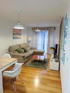 een woonkamer met een bank en een tafel bij Apartamento Mar de Arousa in Ribeira