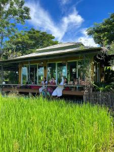 eine Gruppe von Menschen, die vor einem Haus stehen in der Unterkunft Phoo Na Resort in Chiang Mai