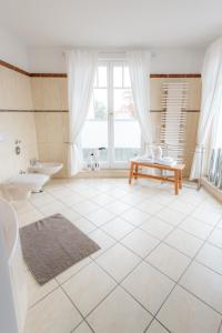 uma casa de banho com 2 lavatórios, um WC e uma janela em Villa Düne mit großer Sonnenterrasse, Kamin, Wlan und Tiefgarage für 2-4 Personen em Kühlungsborn