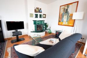 a living room with a couch and a tv at Villa Düne mit großer Sonnenterrasse, Kamin, Wlan und Tiefgarage für 2-4 Personen in Kühlungsborn