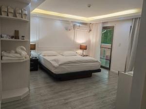 um quarto com uma cama grande e uma janela grande em LATA HOTEL em Hofoa