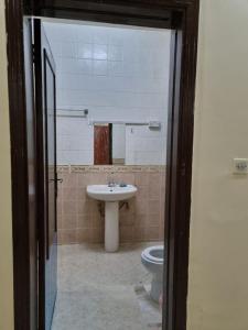 y baño con lavabo y aseo. en Budget Hostel Rooms, en Al Ain