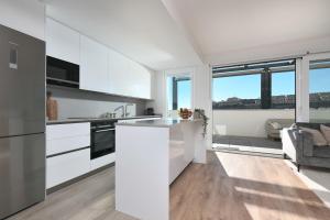 une cuisine avec des placards blancs et une grande fenêtre dans l'établissement Amazing 3 bedroom penthouse with private pool in Cala Serena - La Cala, à Malaga