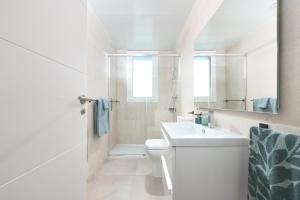 La salle de bains blanche est pourvue d'un lavabo et de toilettes. dans l'établissement Amazing 3 bedroom penthouse with private pool in Cala Serena - La Cala, à Malaga