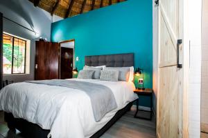 a blue bedroom with a bed and a blue wall at Wildevy at Benlize in Hartbeespoort