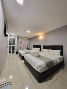 a bedroom with two beds and a large window at Royale City Hotel - 10 min from KLIA KLIA 2 Airport in Sepang