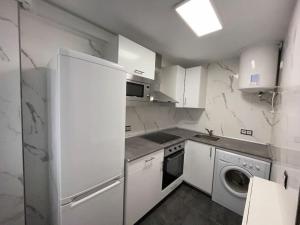 eine weiße Küche mit einem Kühlschrank und einem Geschirrspüler in der Unterkunft Apto. a estrenar en el centro 2 hab y 1 baño in Castro-Urdiales