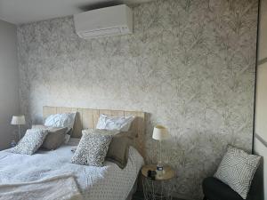 ein Schlafzimmer mit einem Bett und einer Tapetenwand in der Unterkunft Chez Marianne in Wailly