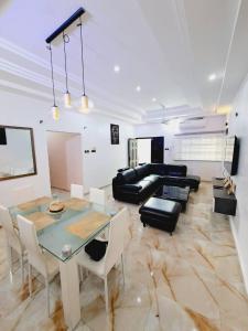 uma sala de estar com uma mesa e um sofá em Domicile Houéyiho 2 em Cotonou