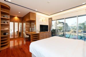 um quarto com uma cama e uma secretária com uma televisão em Capitel Rama 4 em Bangkok