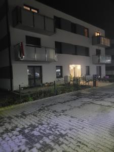 an empty street in front of a building at night at Apartament Złota Dziewiątka in Wągrowiec