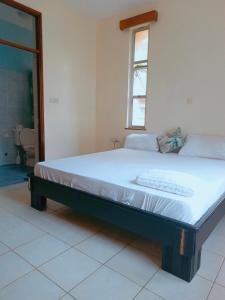 een groot bed in een kamer met een raam bij 2 Bedroom KMA Mtwapa Estate in Mtwapa