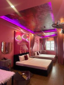 een slaapkamer met 2 bedden en paarse verlichting bij Khách sạn Tình Yêu in Ho Chi Minh-stad
