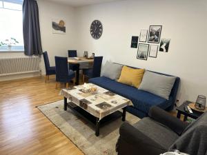 Una sala de estar con un sofá azul y una mesa. en Urlaub in Schlossnähe, en Artstetten