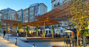 un restaurant avec des tables et des parasols dans une ville dans l'établissement Precioso Piso en el Centro de Vigo, à Vigo