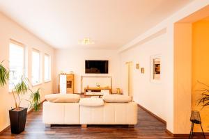 - deux lits dans un salon avec un canapé blanc dans l'établissement Großzügiges Apartment im Loft-Stil, à Bad Berneck im Fichtelgebirge