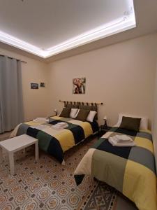 a bedroom with two beds and a table at Room Sixty One in Palermo