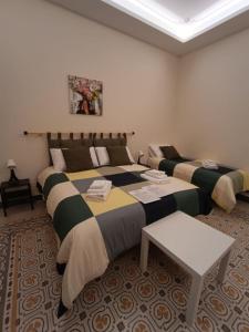 a hotel room with two beds and a table at Room Sixty One in Palermo