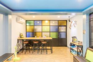 uma cozinha com uma mesa e bancos num quarto em Blueplace บลูเพลส em Ban Talat Rangsit