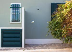 a building with two garage doors and a window at I Mandorli in Porto Conte