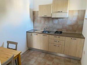 - une cuisine avec des placards en bois, un évier et une table dans l'établissement RESIDENZA IN PIAZZETTA, à Vasto